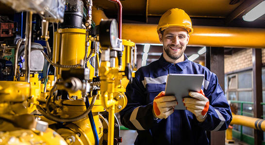 Engineer standing by natural gas installations and pipeline checking consumption on tablet computer application