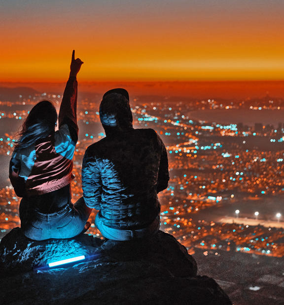 Couple overlooking the city. Night time with dramatic landscape