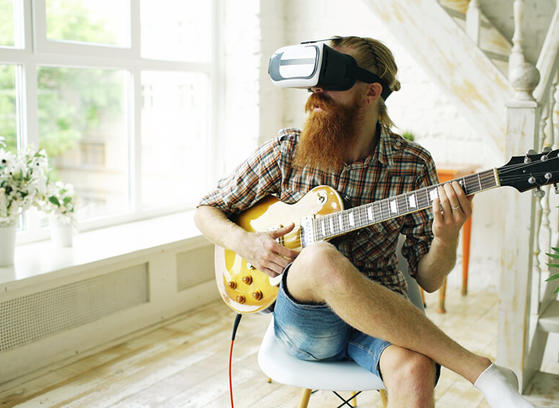 Guy playing guitar wearing VR glasses