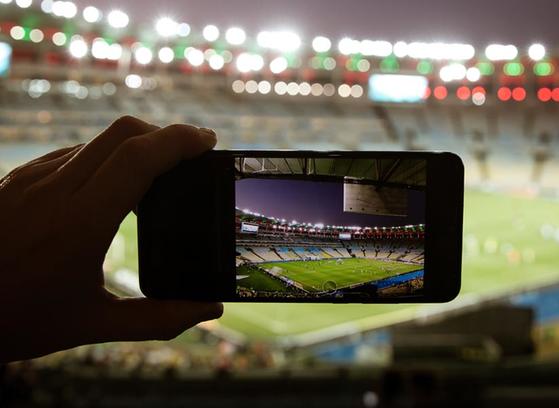 Taking photo with mobile phone on large sports arena