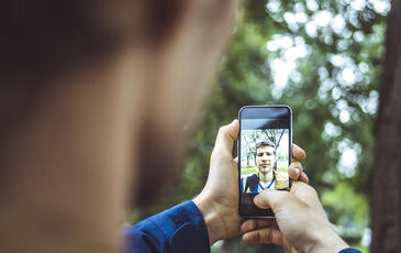 young man making a selfie outdoors with smartphone