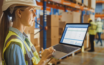 Woman with laptop at manufacturing floor