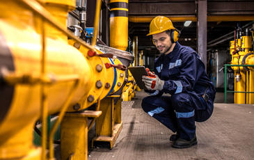 Industrial technician checking gas pipeline installations inside refinery