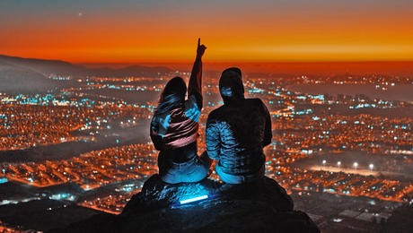 Couple overlooking the city. Night time with dramatic landscape