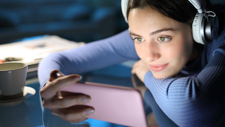 Woman watching media on smartphone in home environment
