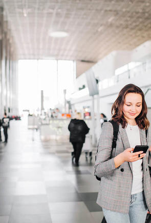 Woman at airport holding a phone