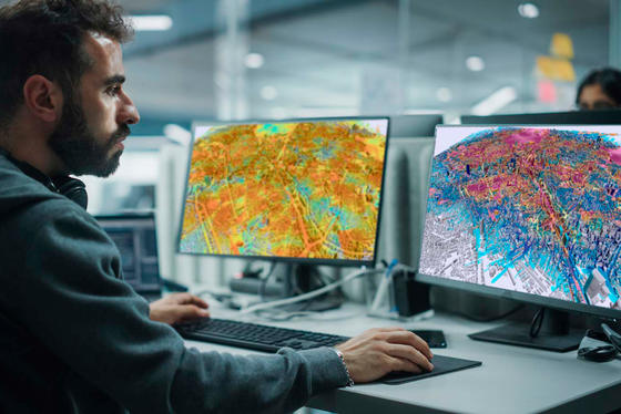 Man working in front of two monitors with Planet application